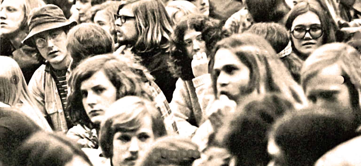 Crowd of young people gathered at a protest or concert, representing the historical significance of music and news archives, with diverse individuals showcasing cultural and social moments.