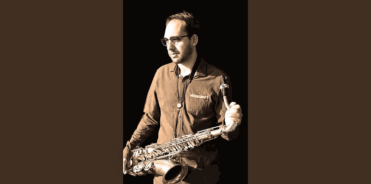 Saxophonist holding his instrument in a sepia-toned photograph, symbolizing music and jazz culture, aligned with Past Daily's focus on music history and archival sound recordings.