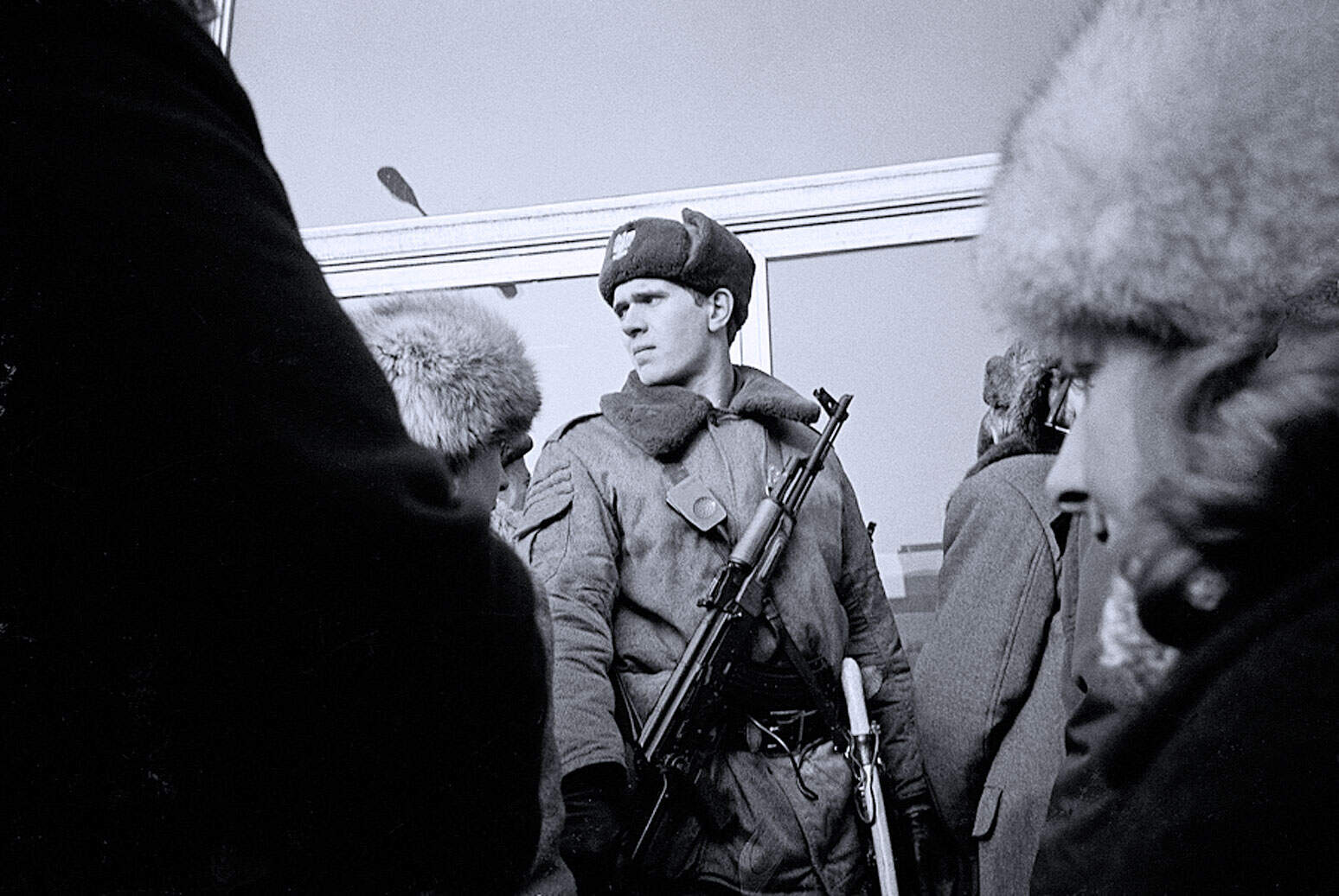 French soldier in cold weather military uniform during winter Cold War era, historical war military personnel, black and white photo of armed soldier in uniform at border Military history, news, and war archive images for research and reference.