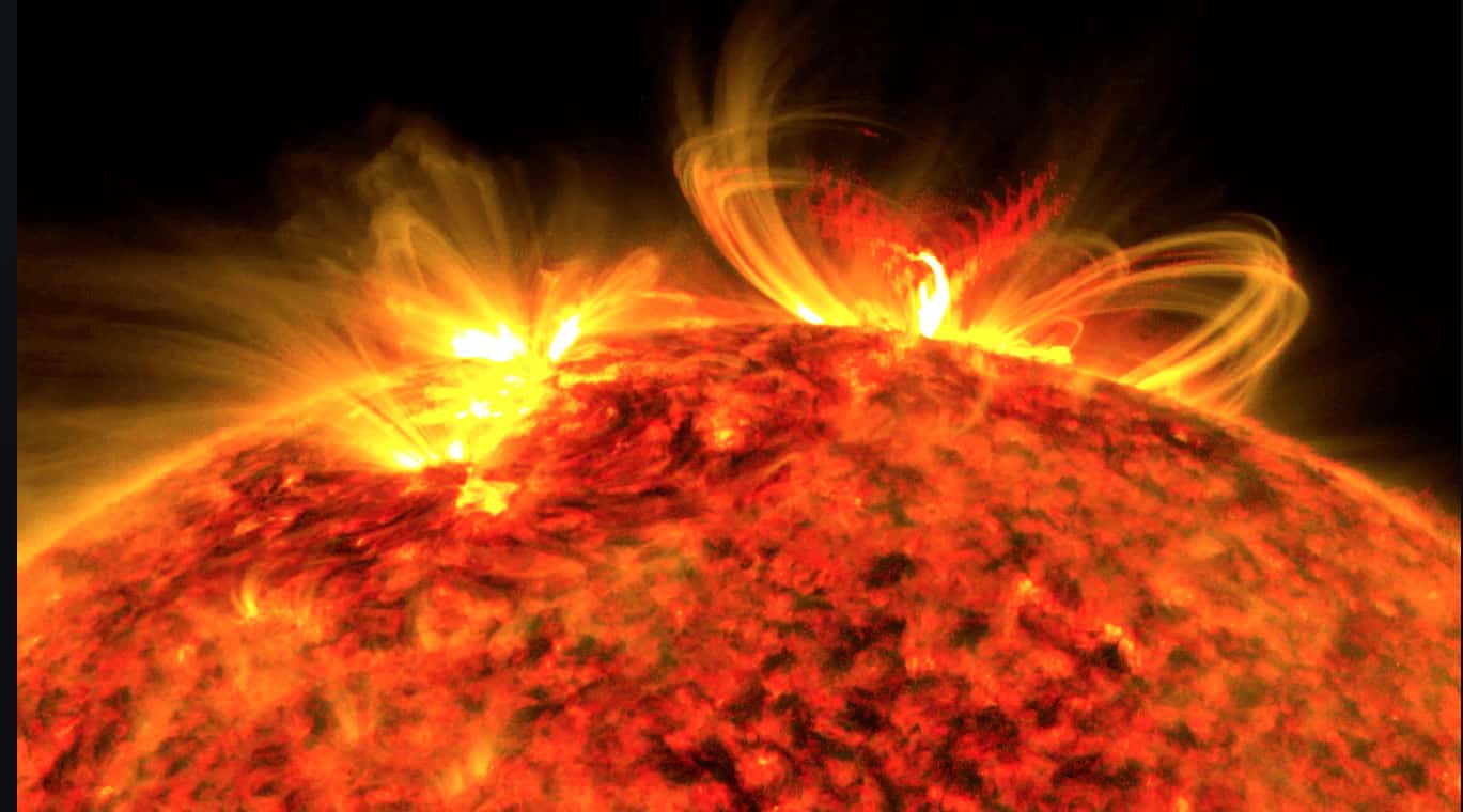Bright solar flare erupting from the sun with intense flames and plasma loops, capturing the dynamic activity of the sun's surface.