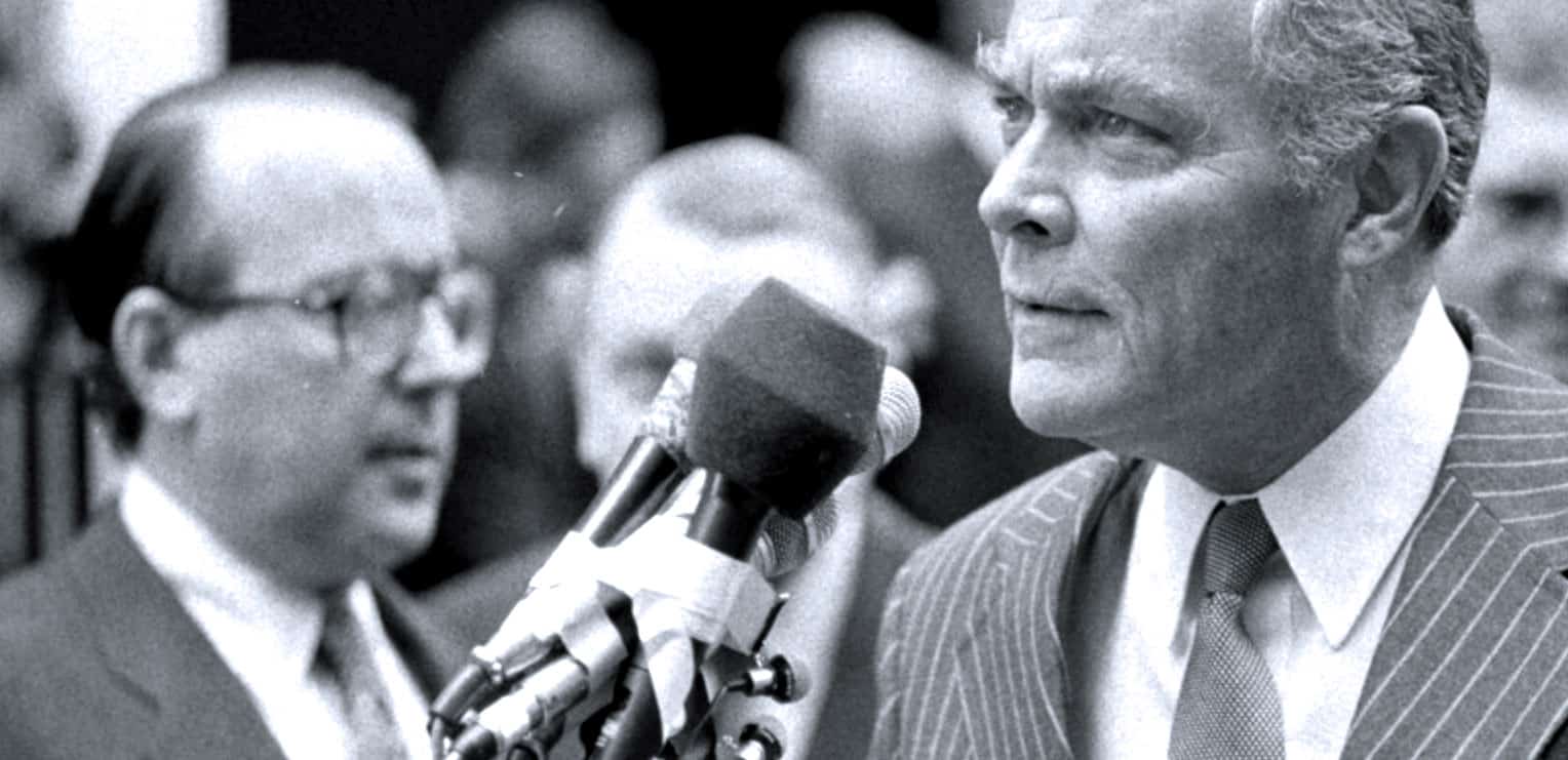 President John F. Kennedy giving a speech with microphone, historical black and white image, political news and history archive.