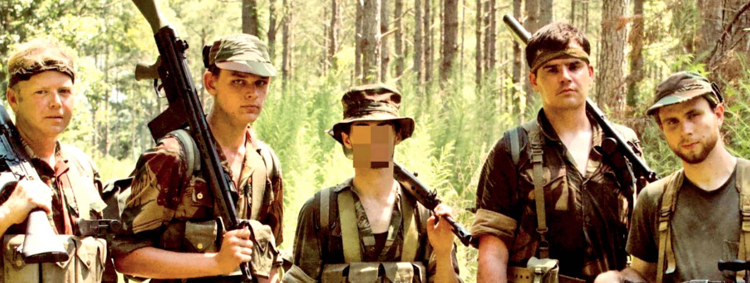 Soldiers in camouflage gear holding weapons in a forest setting on a military expedition.