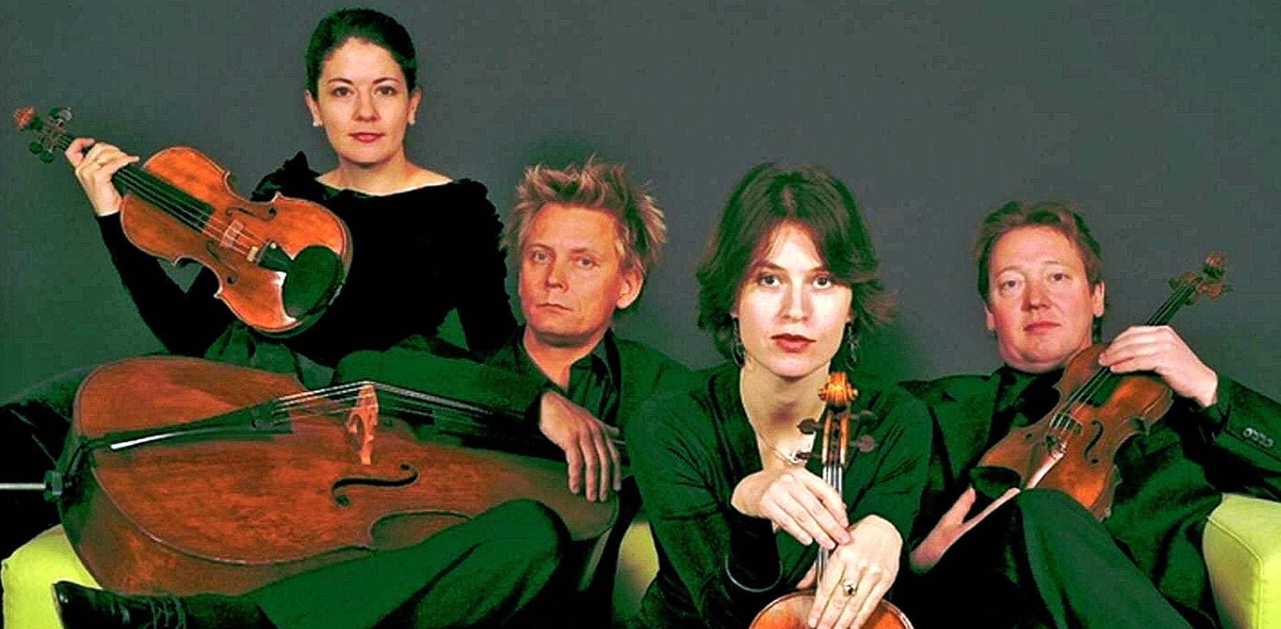 Elegant string quartet with violins and a cello, performing classical music in a studio setting, representing timeless artistry and musical heritage.
