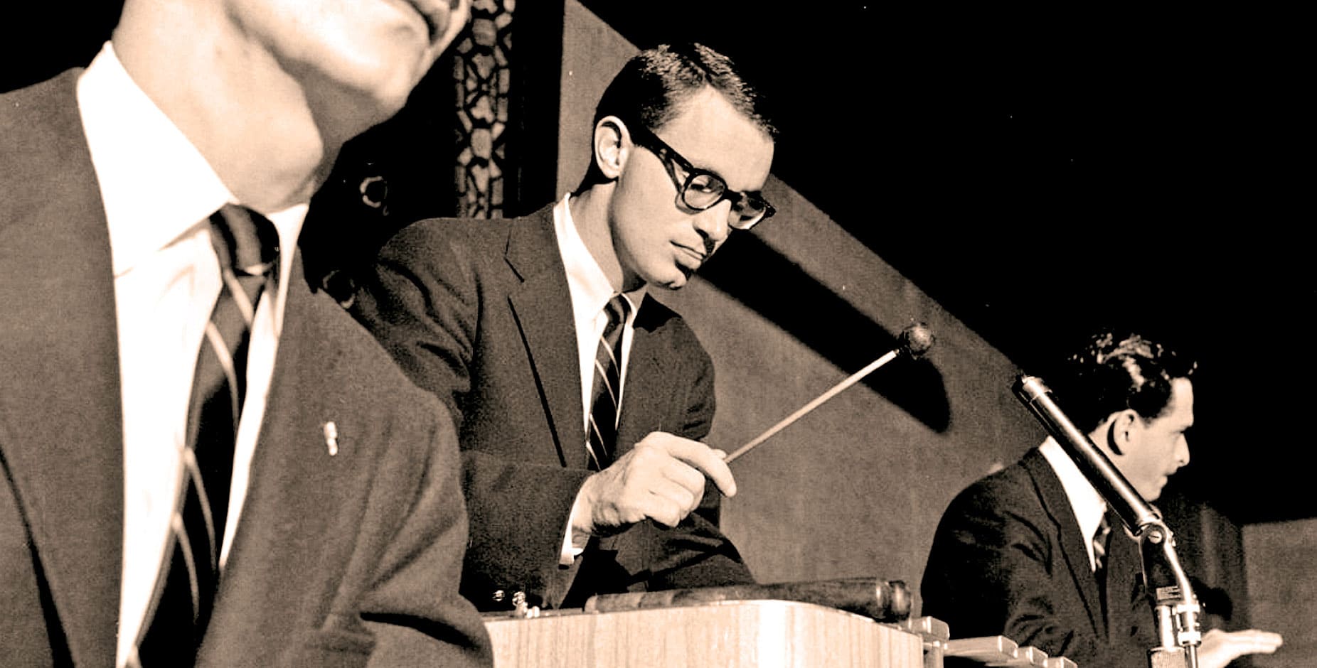 Vintage black and white photo of a male conductor and musicians during a historic jazz or big band performance, emphasizing music history and classic performances.