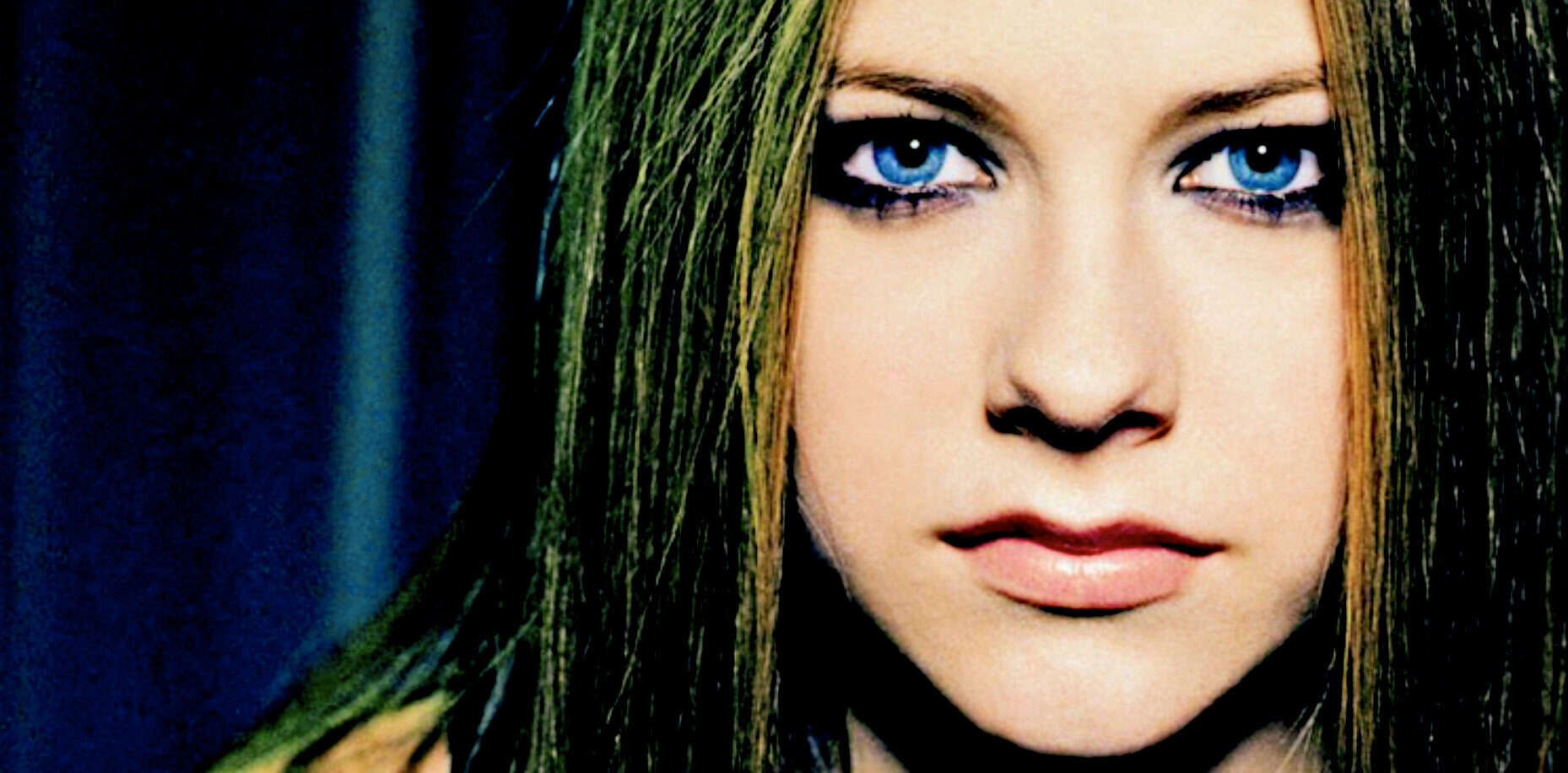 Blue-eyed woman with long straight hair and bold makeup, portrait of female model with striking eyes and flawless skin, fashion and beauty photography, elegant and modern style, high-resolution image for magazine or cosmetic ad.