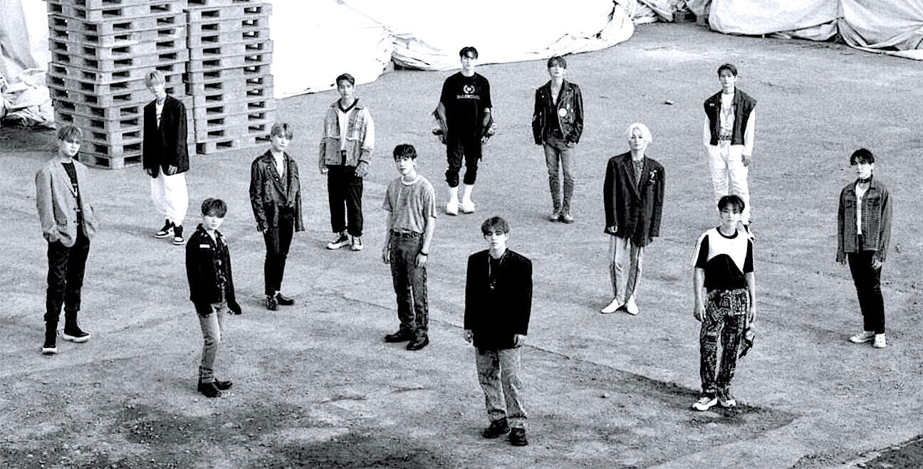 Teenage boys and girls standing apart in an outdoor setting, emphasizing themes of youth culture and fashion. Black and white photo capturing modern streetwear styles and social distancing practices.