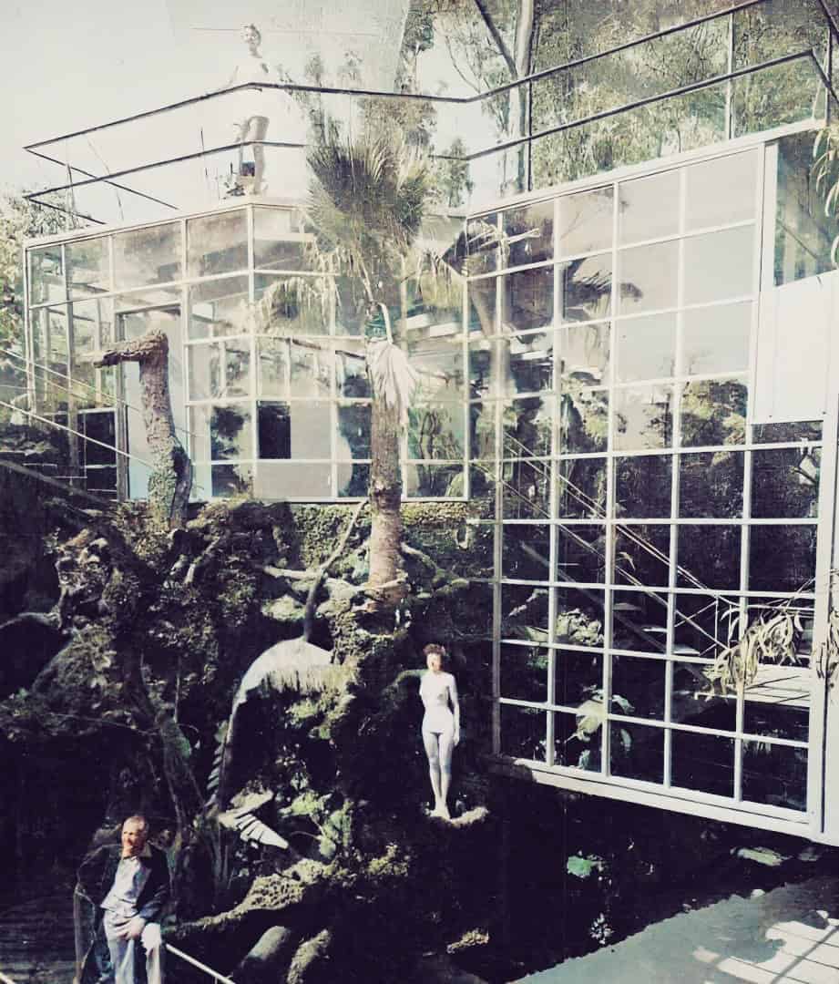 Modern glass architecture blending with lush tropical nature, showcasing innovative design and ecological harmony in a contemporary building.