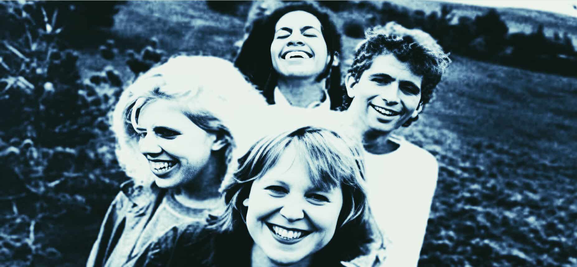 Smiling diverse group of young people outdoors, representing music, news, and history archives, capturing joyful moments and cultural moments for historical sound recordings.