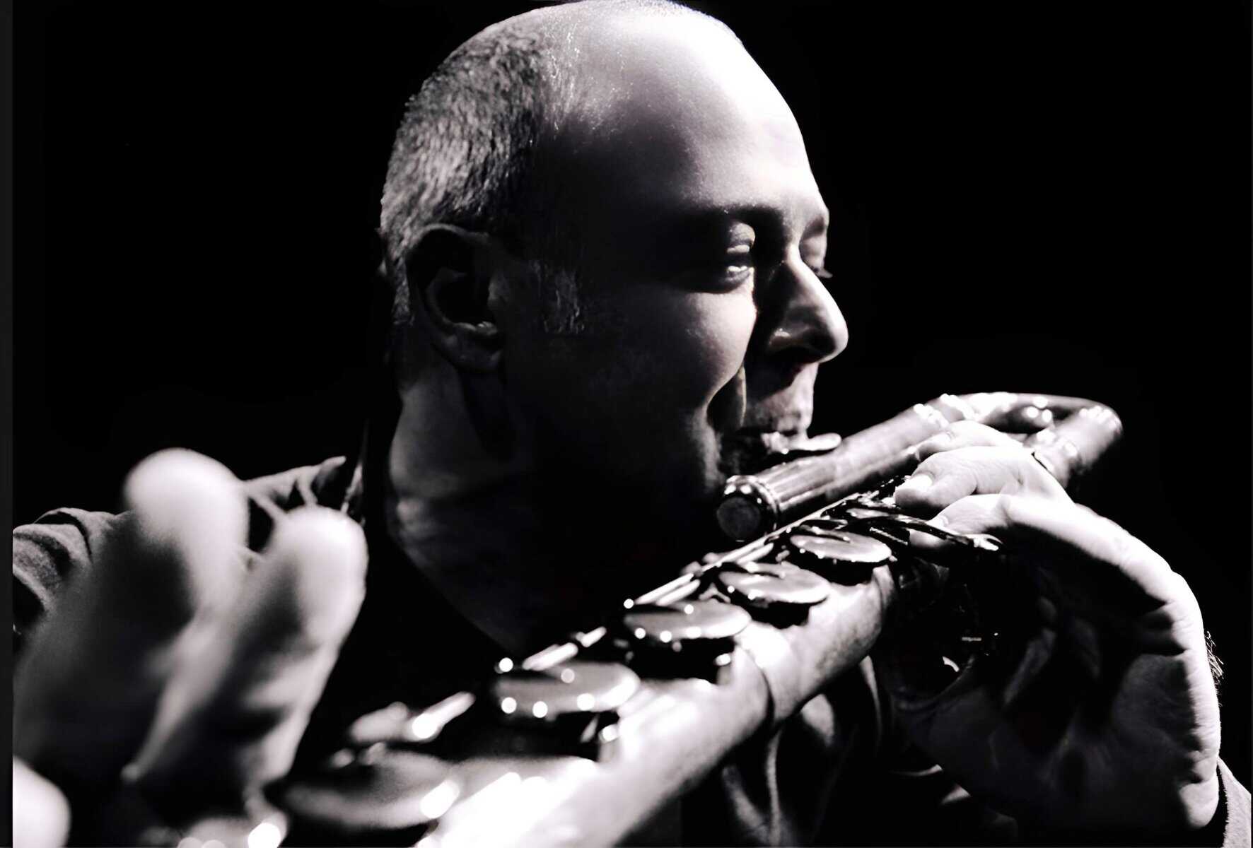 A black and white close-up of a musician playing the flute, emphasizing the artistry and history of music preserved in the Past Daily sound archive of news, history, and music.