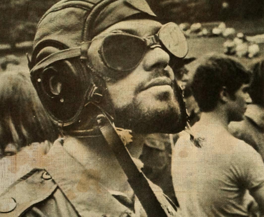 Pilot wearing goggles and helmet, preparing for flight, vintage military aviation photo, historical aircraft pilot, black and white archive image, vintage aviation history, military pilot gear, 1960s air force.