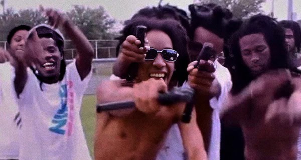 Youth protest with passionate individuals holding guns, expressing activism and resistance, vibrant and energetic scene in an outdoor setting.