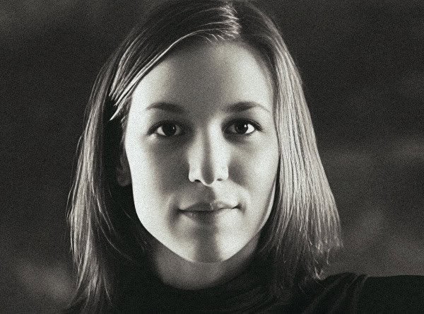 Woman with shoulder-length hair looking directly at the camera in black and white portrait.