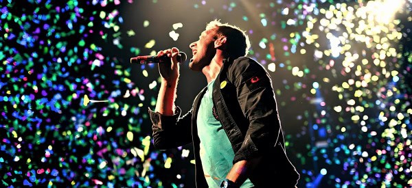 Vibrant concert scene with singer performing on stage amidst colorful confetti and dynamic lighting, capturing the energy of live music performances.