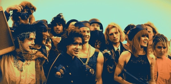 A diverse group of young people smiling and enjoying music outdoors, capturing the vibrant energy of youth culture and live entertainment.