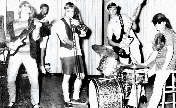 A vintage band performing live with electric guitar, trumpet, bass guitar, drums, and keyboard, showcasing classic music entertainment and nostalgic 1960s or 1970s musical scene.
