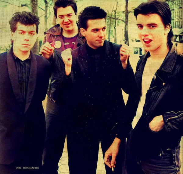 Famous early 1980s punk rock band members posing outdoors, showcasing retro fashion and rebellious attitude. Ideal for images related to music history, punk culture, and 80s music icons.