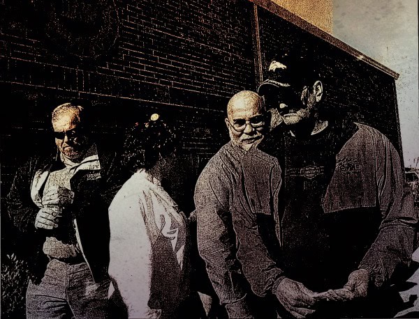 Vintage black and white photo of police officers and civilians engaging in conversation outside a building, capturing local news and community history; reflects historical moments preserved in news archives.