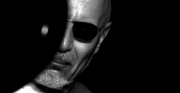 High-contrast black and white image of a man with sunglasses, emphasizing music and historical audio archives on Past Daily website.