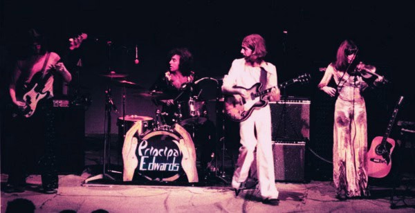 Vintage rock band performing live on stage with instruments and energetic presence, capturing classic music moments.