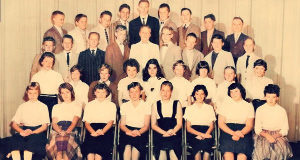 Group of school children in uniform from a vintage classroom photo, capturing a nostalgic moment in educational history.