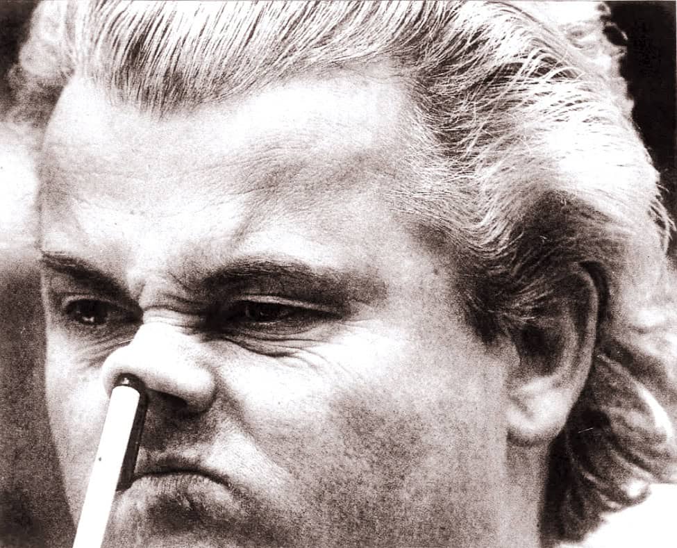 Close-up black and white photo of Donald Trump with a cigarette in his nose, showing intense facial expression — a historic and controversial image.