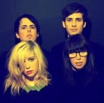 Young indie band members posing for promotional photo, showcasing diverse musical artists for news, music history, and sound archive website.
