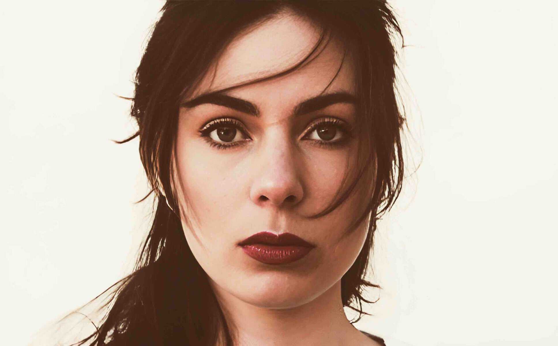 Striking portrait of a woman with dark hair and expressive eyes, emphasizing beauty and elegance. Perfect for visuals related to fashion, lifestyle, or personal style content.