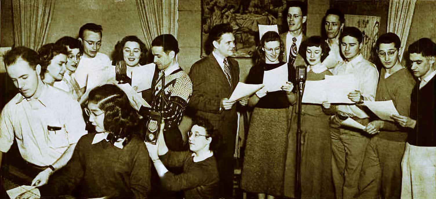 Vintage radio broadcast with a group of people singing and recording in a historic sound archive setting.