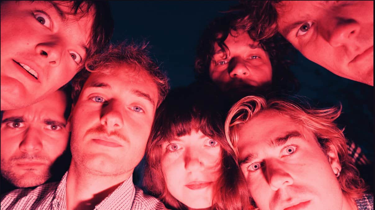 Close-up of the band Oasis with focused lighting, showcasing the band members' faces, capturing their iconic 90s rock style, promoting music history and nostalgia.