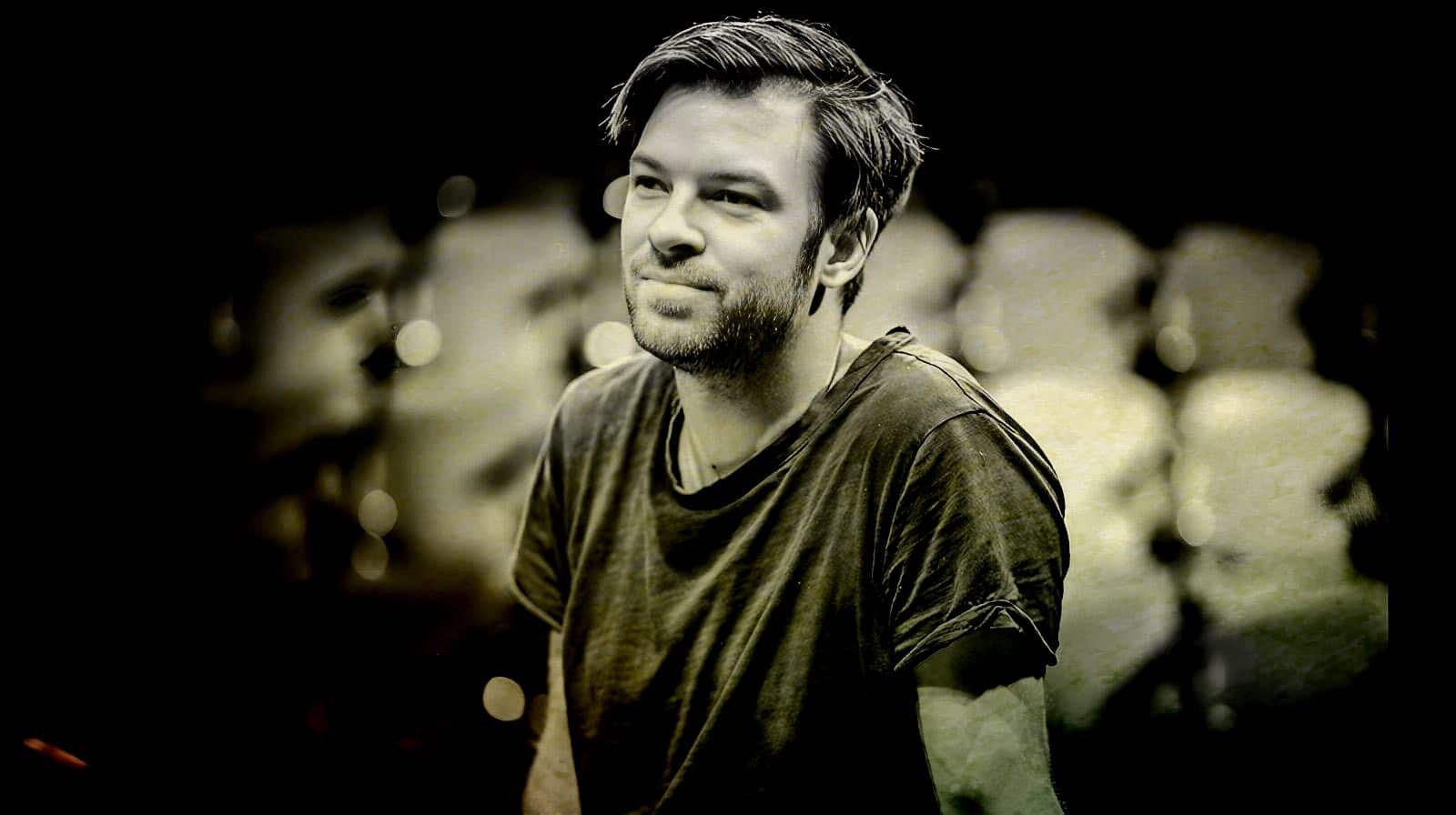 Portrait of a young man with a contemplative expression, black and white image, emphasizing mood and nostalgic tone, ideal for a sound archive of news, history, and music.