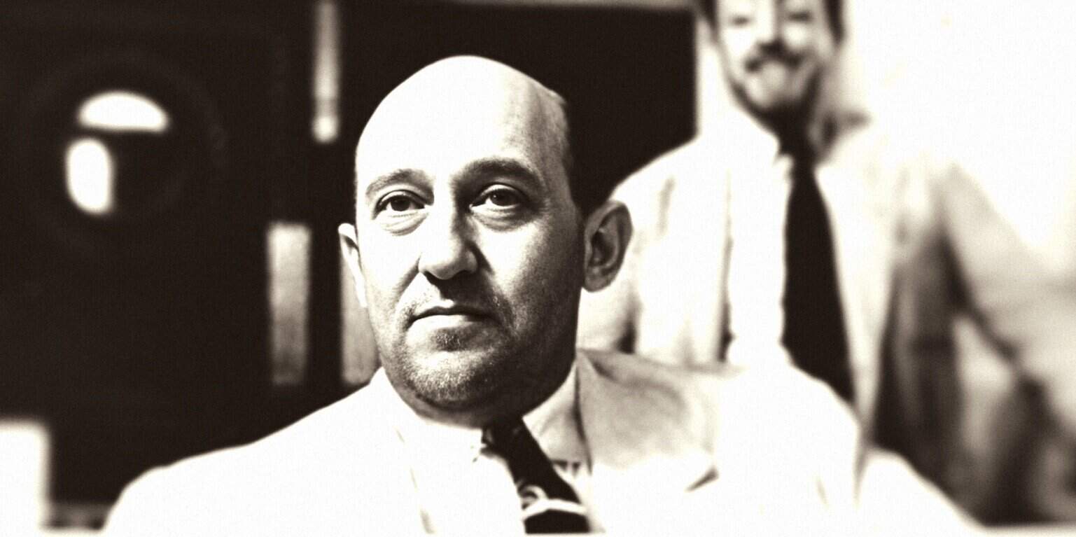 Historian in a suit and tie, black and white photo, representing news, history, and archival media, promoting Past Daily: A Sound Archive of News, History, and Music.