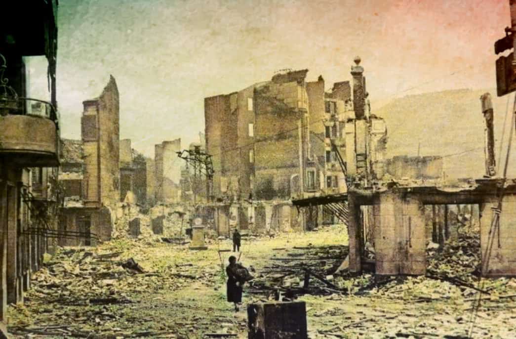 Destroyed city street after bombing, ruins and debris, historical war damage, urban destruction, post-war devastation, vintage black and white photo, historic conflict site, war-torn landscape, mid-20th century destruction, past daily sound archive.