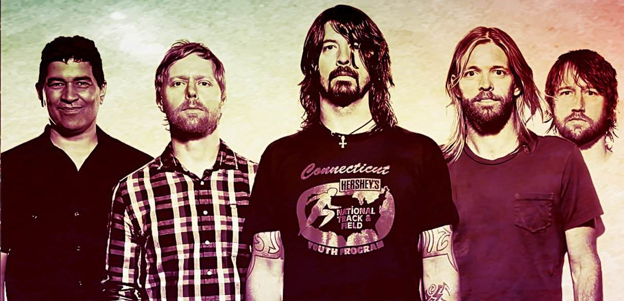 Vibrant band photo of five male musicians with diverse hairstyles and facial hair, showcasing their unique style, representing classic rock and music history, aligned with Past Daily's sound archive of news, history, and music.