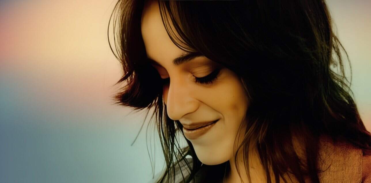 Soft-focus portrait of a smiling woman with dark hair, emphasizing beauty, happiness, and emotional well-being, suitable for content related to music, news archives, and historical sound recordings.