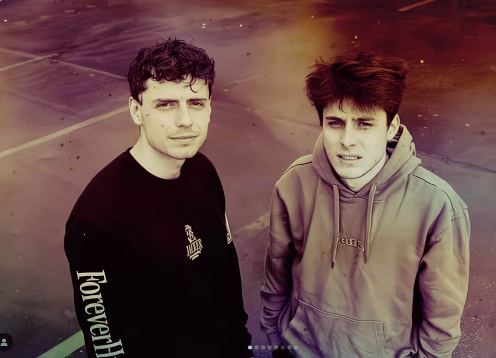 Young men standing on a basketball court, urban streetwear fashion, nostalgic vibe, casual pose, outdoor setting, contemporary youth style, emphasizing music and pop culture.