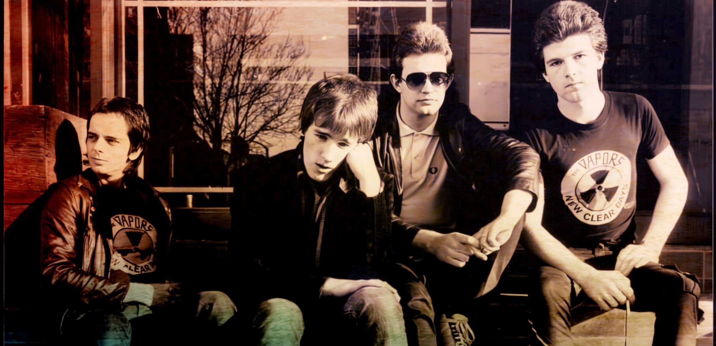 Vintage style photo of a rock band with four young men, cityscape background, wearing casual and leather jackets, epitomizing 1980s music scene, lively and edgy atmosphere.