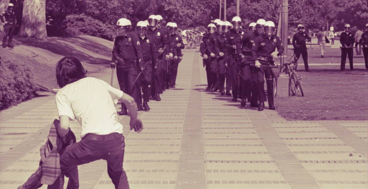 Police officers lined up during protest with demonstrator confronting them on city sidewalk, sound archive of news, history, music.
