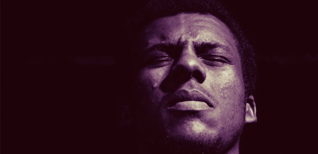 Close-up of a young man with closed eyes and a contemplative expression, highlighting themes of music, history, and sound archives for SEO.