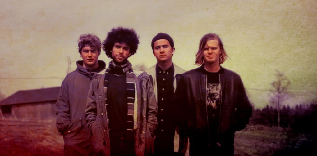 Journalist indie band on rural landscape, music group outdoor photo, alternative music scene, youthful musicians in casual style, nostalgic vintage vibe, Past Daily archive collection, sound archive of news, history, and music, music history preservation, historical photo of bands.