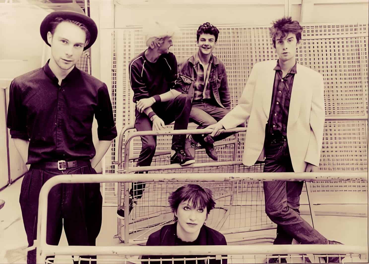 Vintage rock band photo with young musicians, featuring a mix of casual and formal styles, emphasizing music history and 80s/90s music nostalgia.