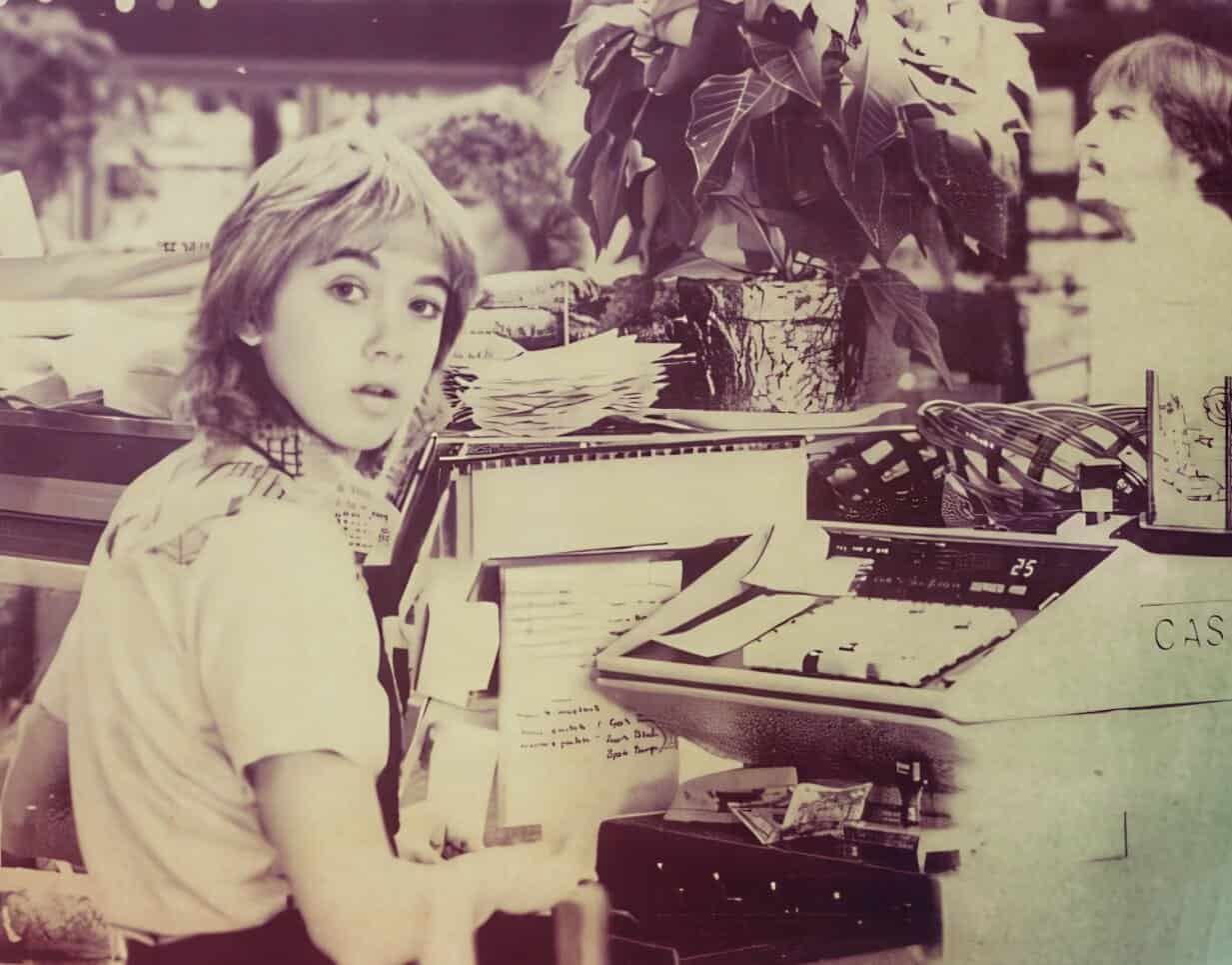 Vintage girl shopping at a grocery store checkout counter with newspapers, magazines, and a cash register, capturing the nostalgic ambiance of past daily news, history, and music archive scenes.