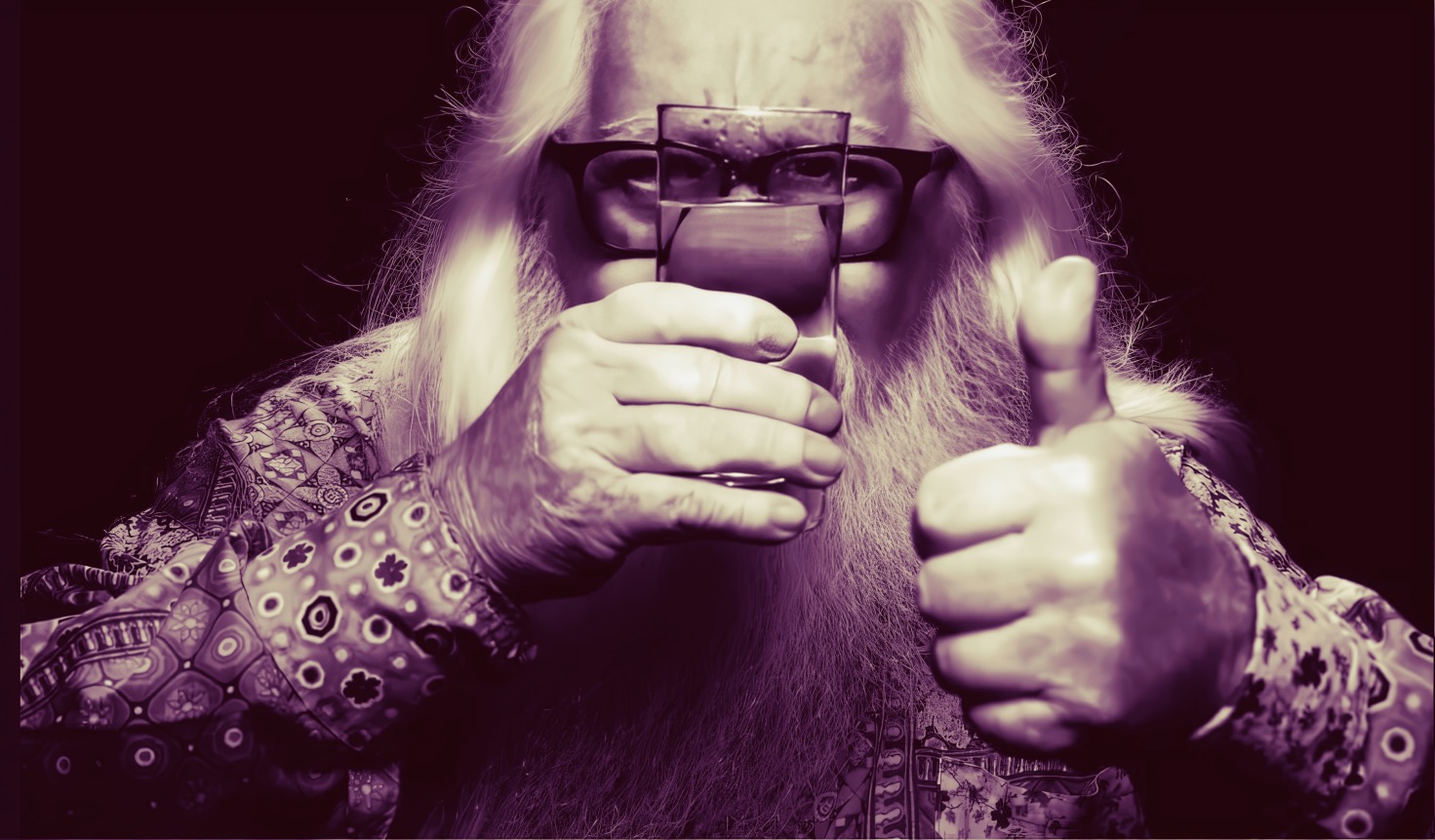 Colorful elderly man with long white hair and beard, wearing patterned shirt, holding a glass of water and giving a thumbs up.