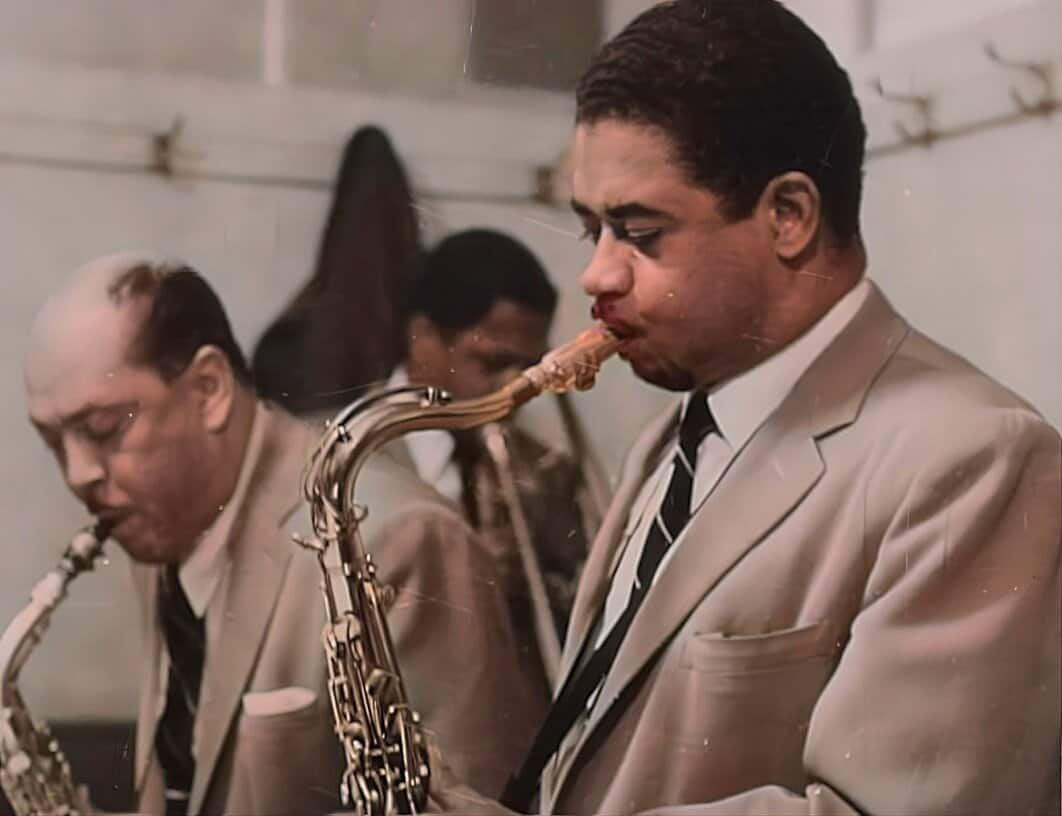 A group of jazz musicians playing saxophones, including a man in a beige suit passionately immersed in the music, capturing a historic jazz performance.
