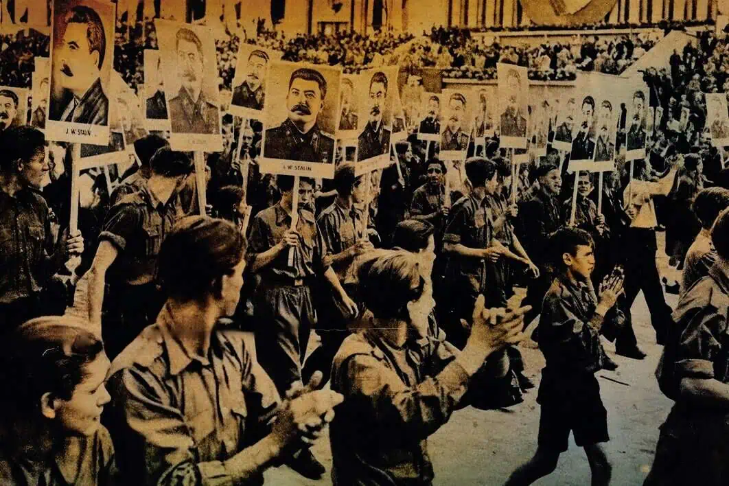 A historical black-and-white photograph of a large crowd of young people holding portraits of military leaders during a political rally or protest. The scene depicts youthful activism and moments from past political history.