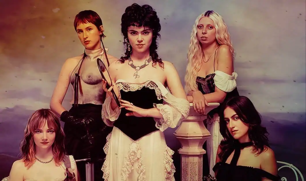 Stock photo of five young women dressed in vintage-style costumes with dark, edgy fashion influences, resembling a gothic or alternative group.