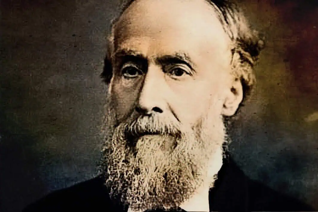 Historical black and white portrait of a distinguished older man with a full beard and mustache, wearing formal attire, representing 19th-century intellectual or political figure for archival historical context.